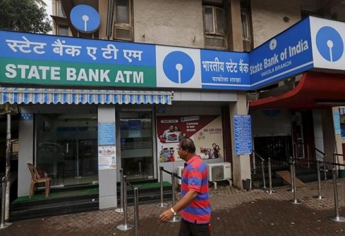 A man walks past an ATM at a State Bank of India branch in Mumbai