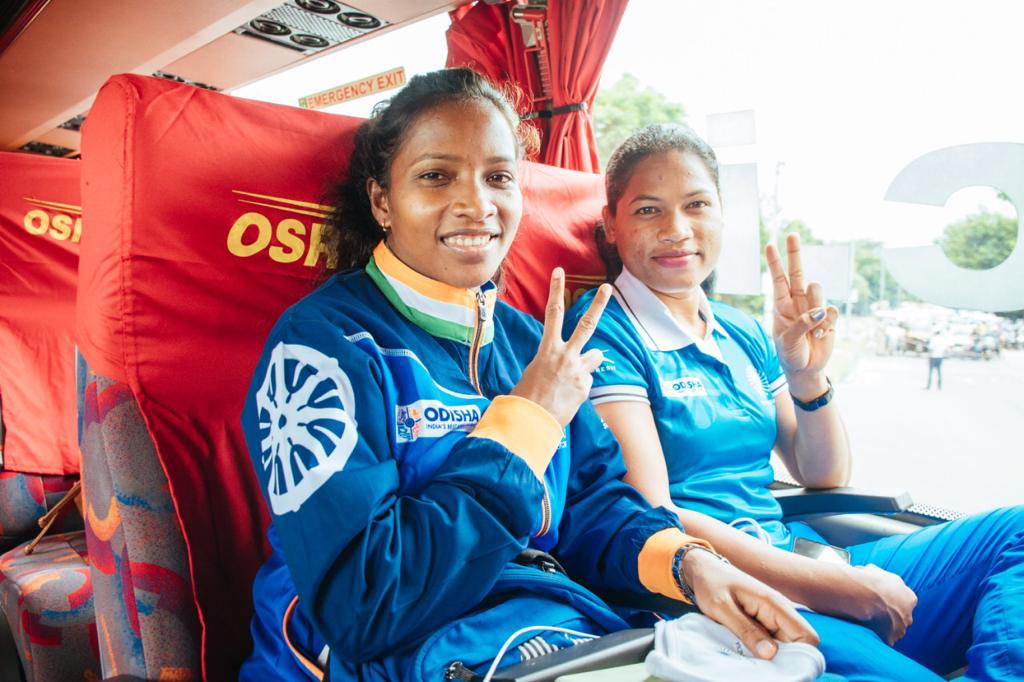 two Indian women's hockey players in bus