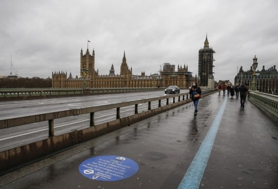 People walk in front of the Houses of Parliament in London, Britain, Dec. 13, 2020.  (Xinhua/Han Yan)